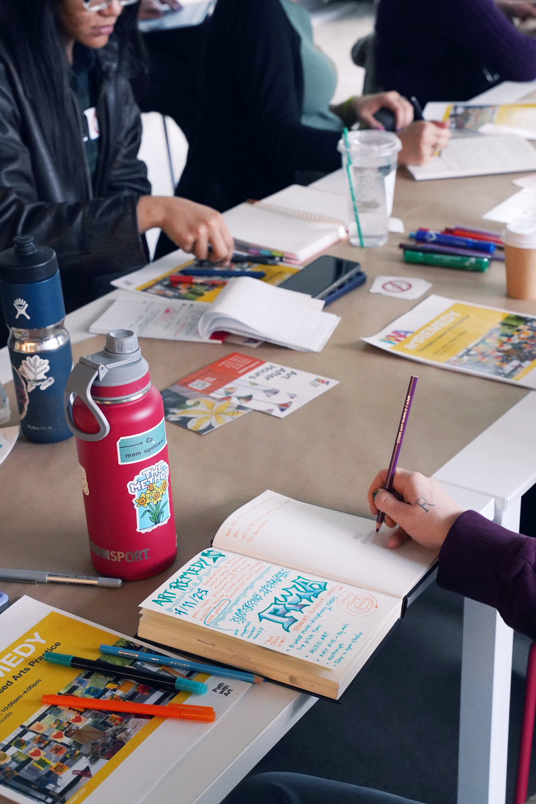 An artREMEDY participant sketches their notes during a training session.