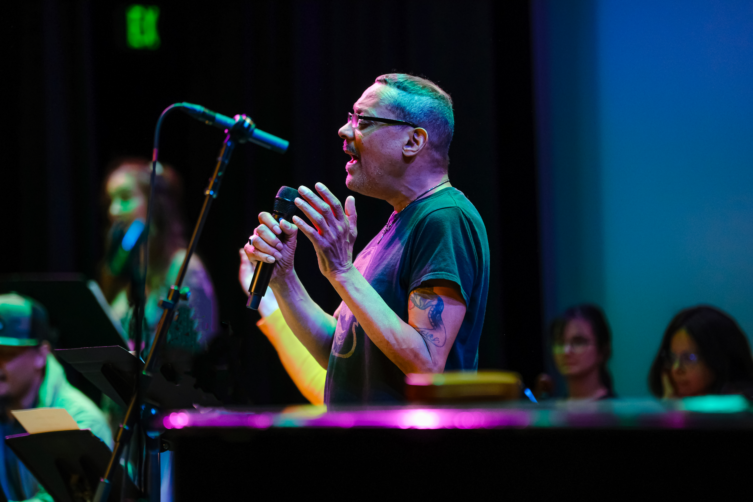 Participant Gary Nelson sings into a microphone with his hands raised