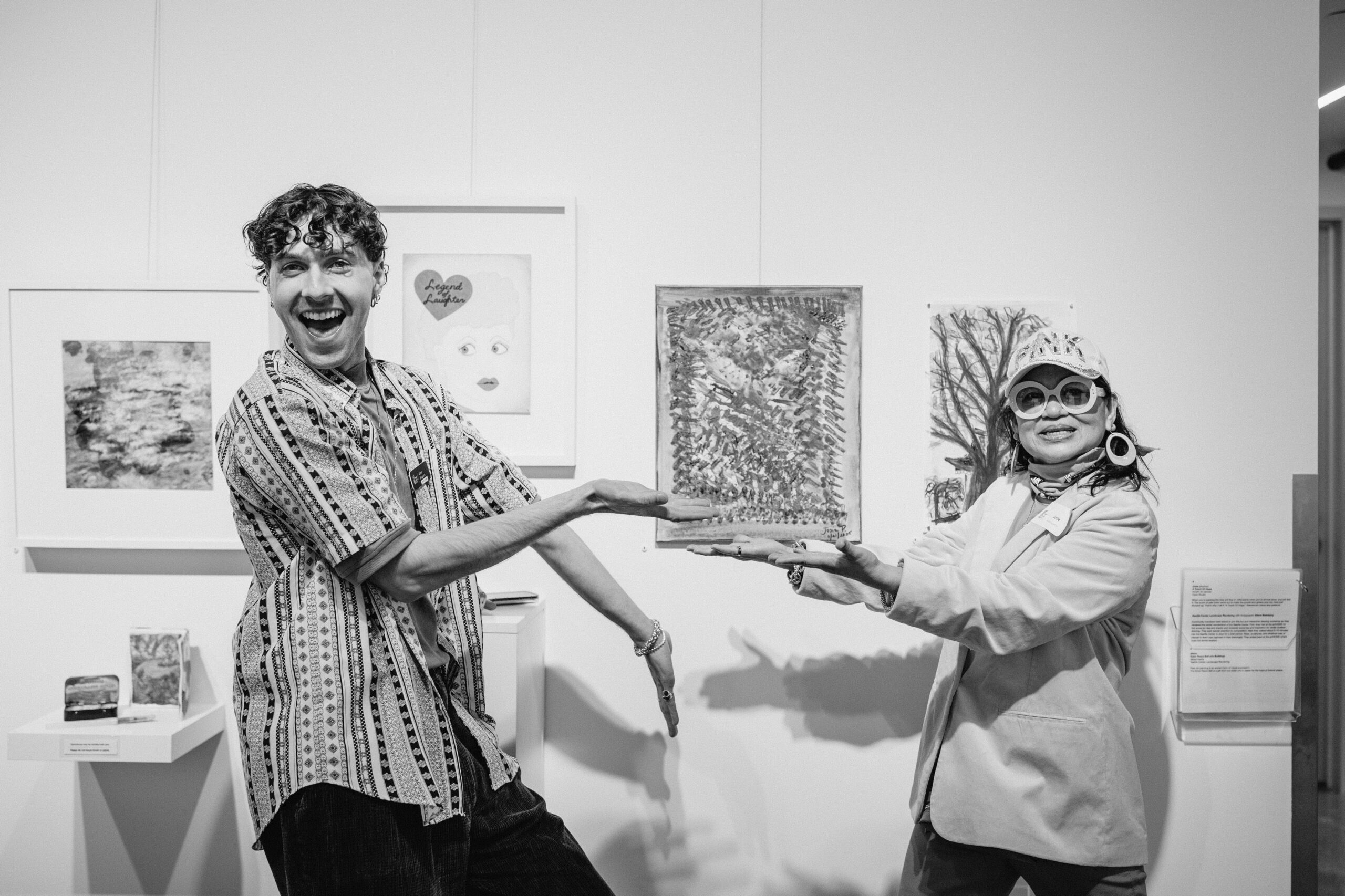 A Participant Artist poses with their work alongside a PwA Arts Team member.