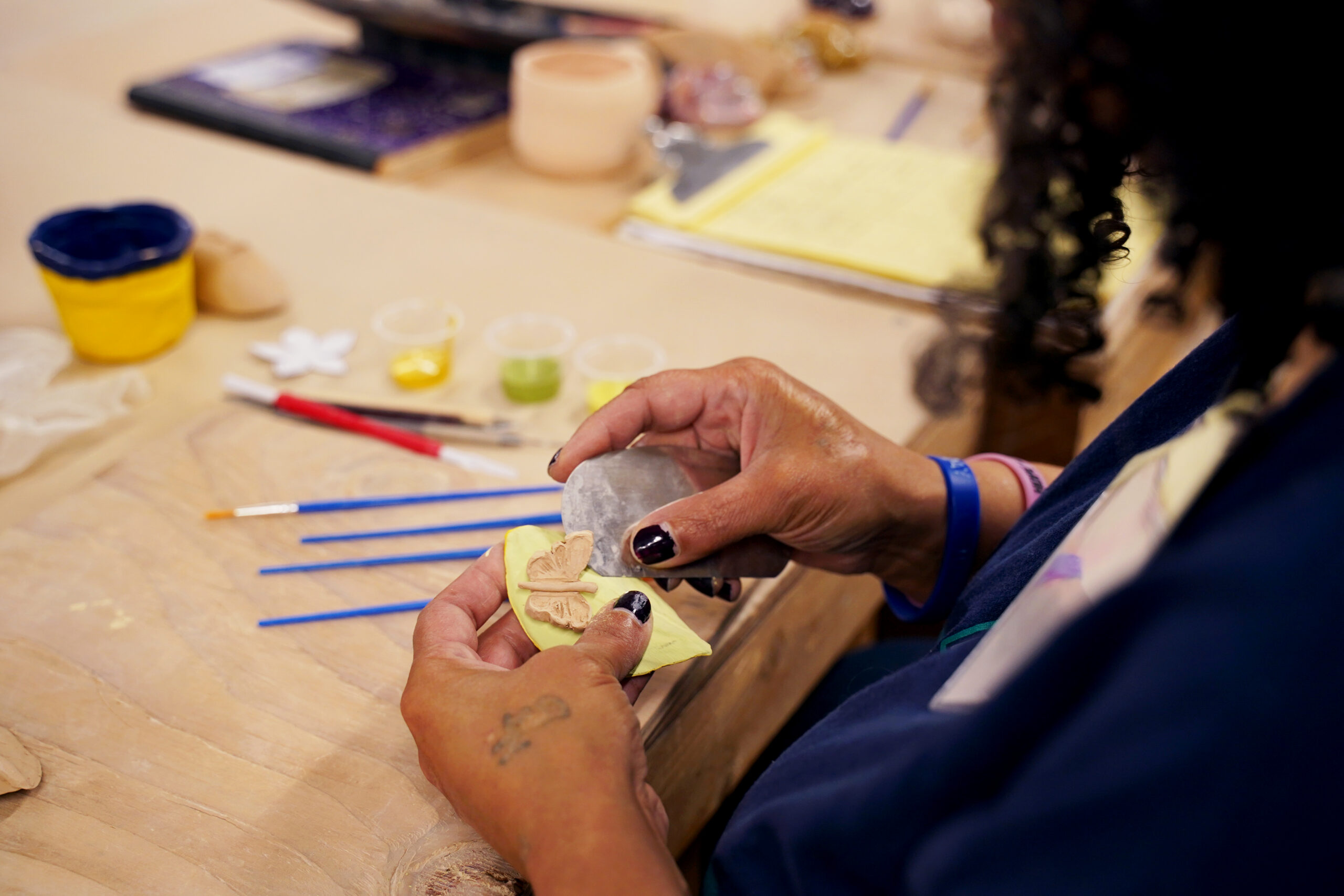 A Participant Artist crafts with clay during a ceramics class at Pottery Northwest.