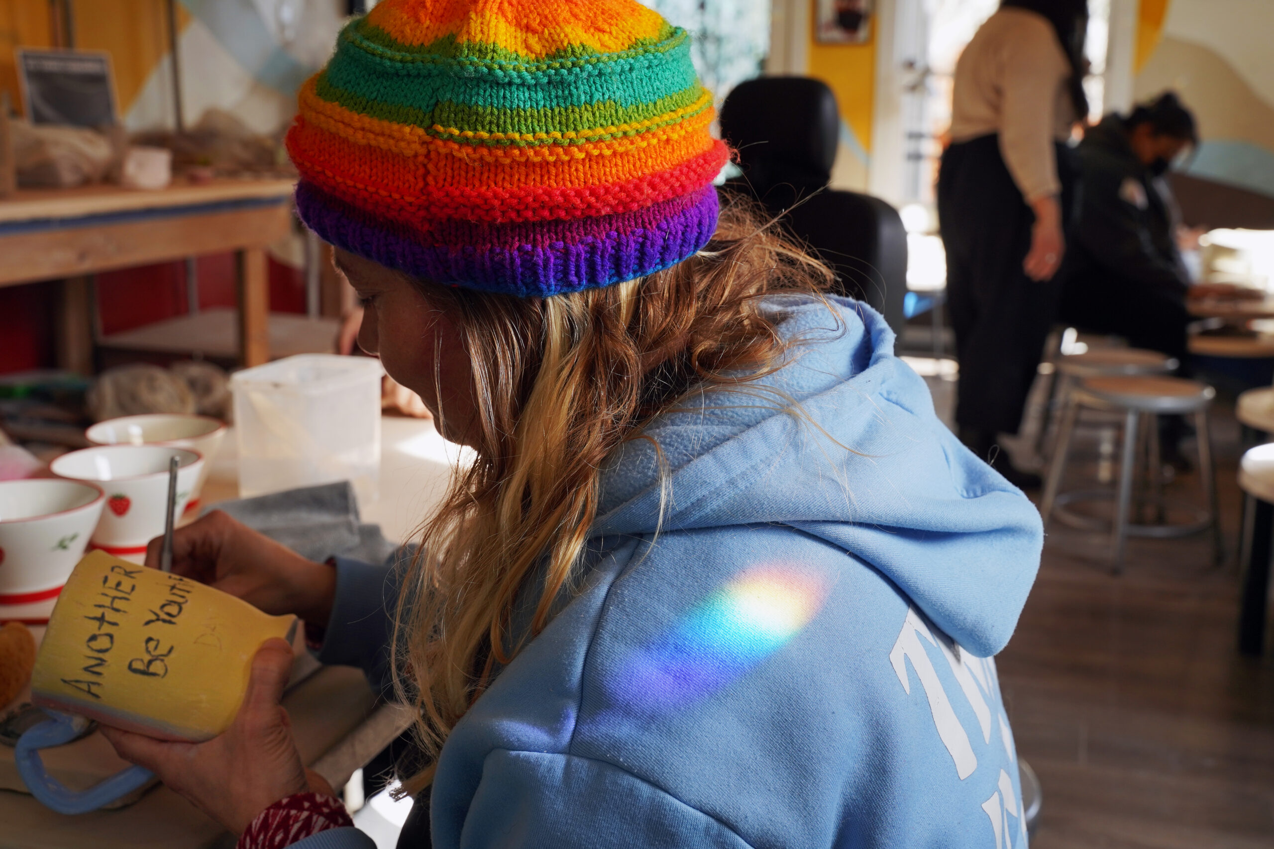 During a ceramics class at Yu Tang Studio, a rainbow graces the shoulder of a Participant Artist.