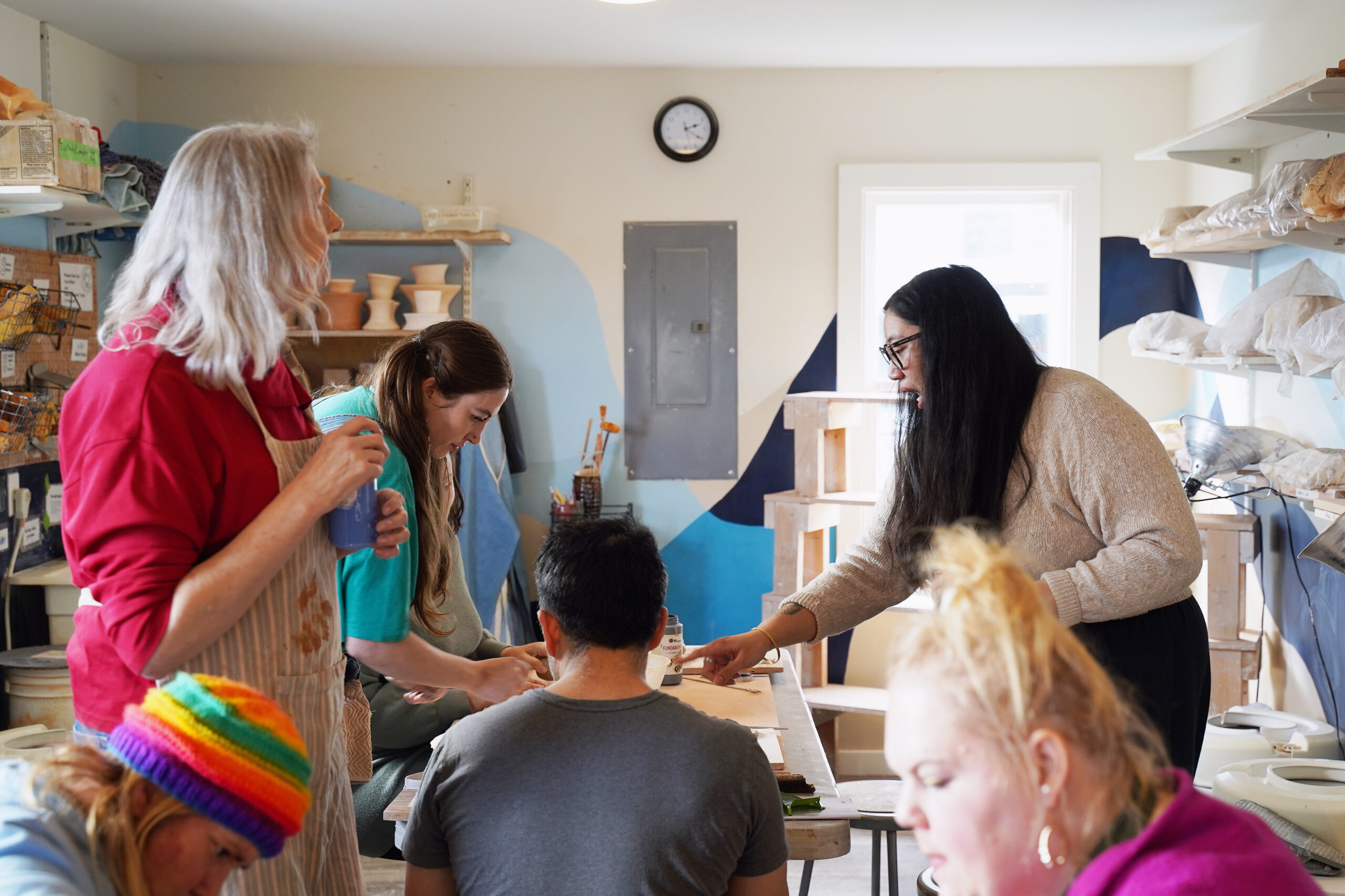 A Teaching Artist, Creative Mentors, and Participant Artists craft ceramics.