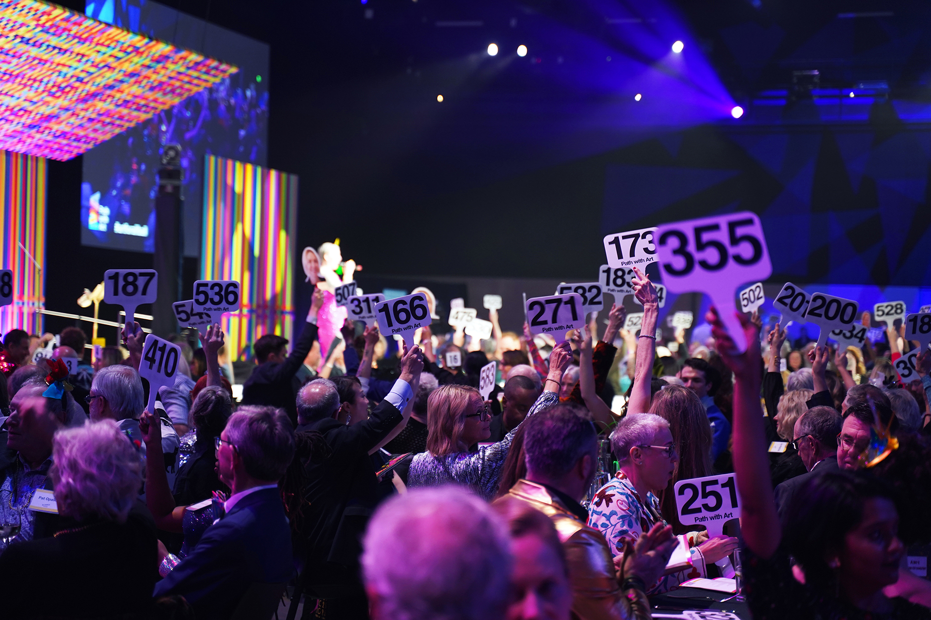 Attendees raise their paddles for the model runway show.