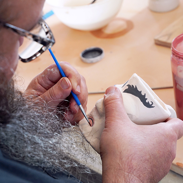 person painting ceramics
