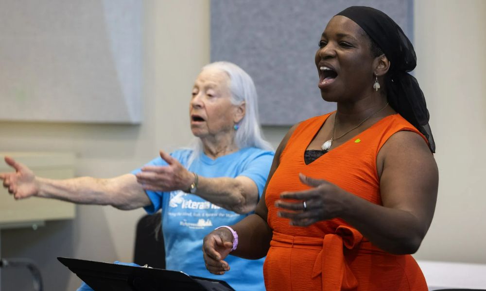 two people singing with arms out